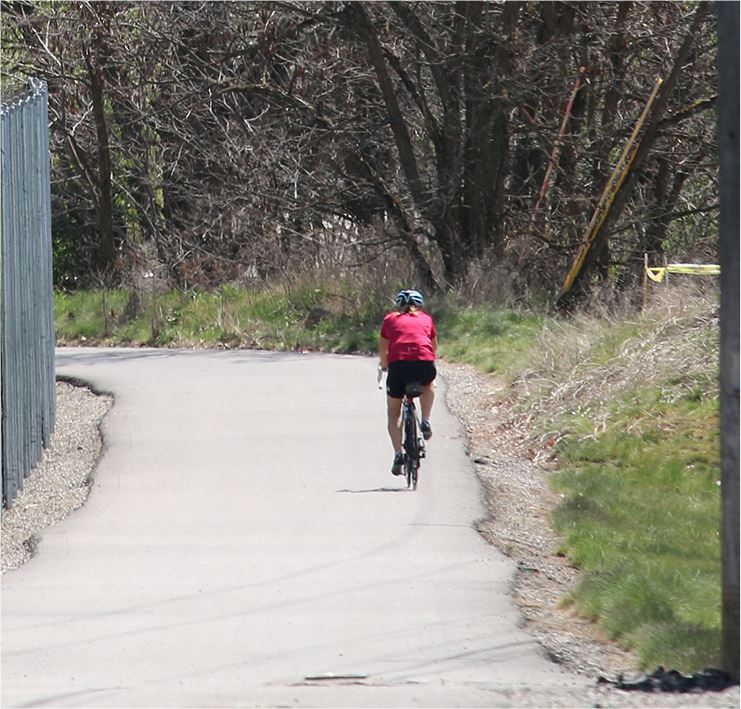 Bicyclist riding down a wooded trail