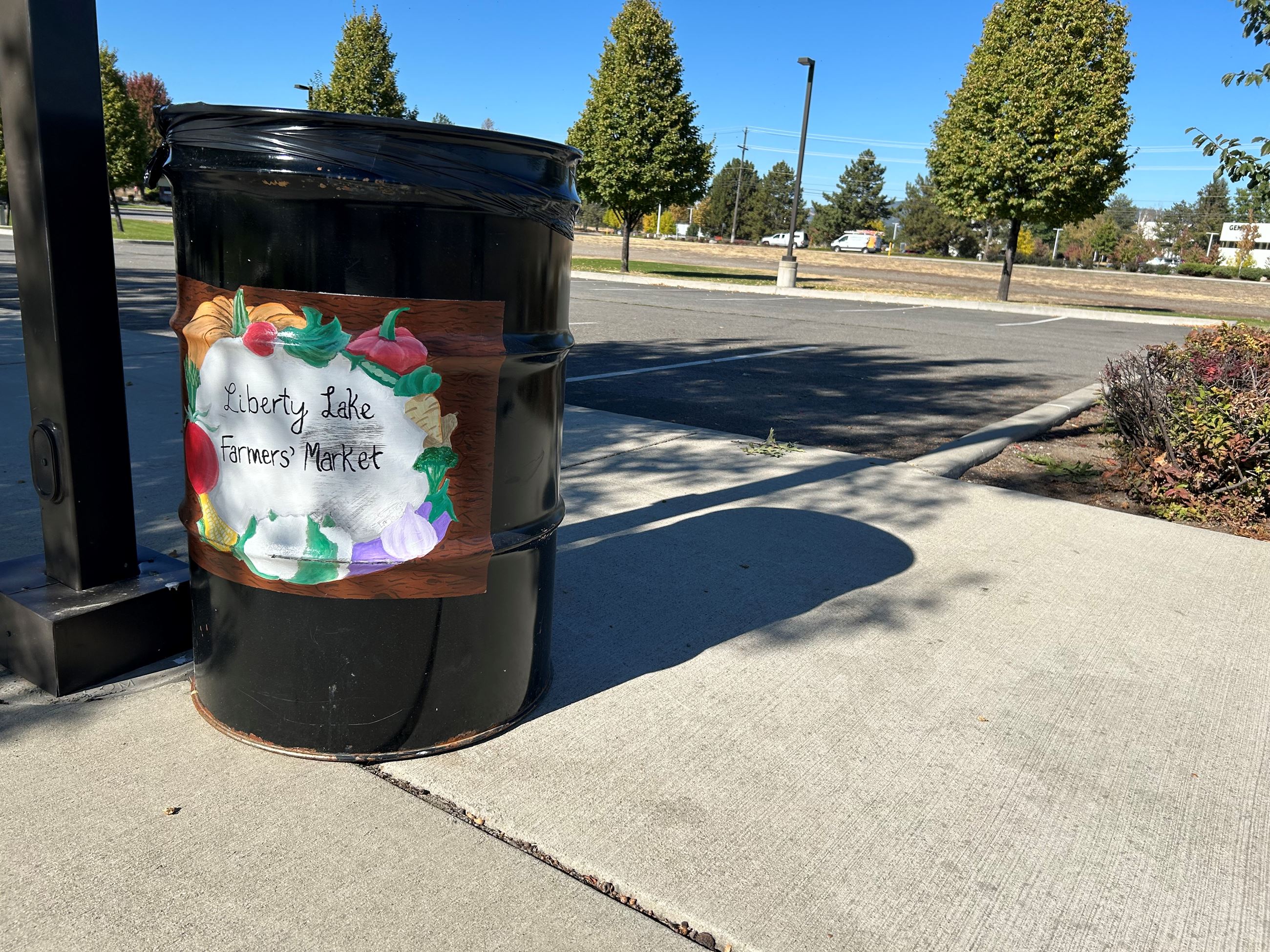 Image of 50 gal metal can with Farmer's Market art painted on it.